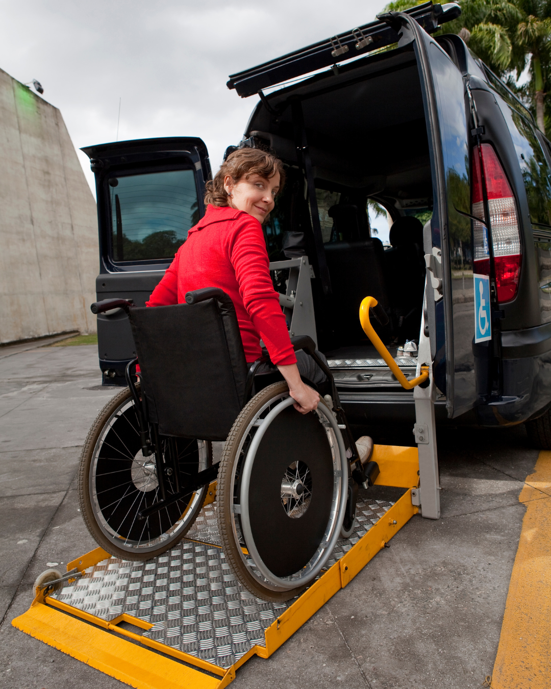 Mujer en silla de ruedas accediendo a vehículo adaptado con plataforma elevadora para transporte accesible
